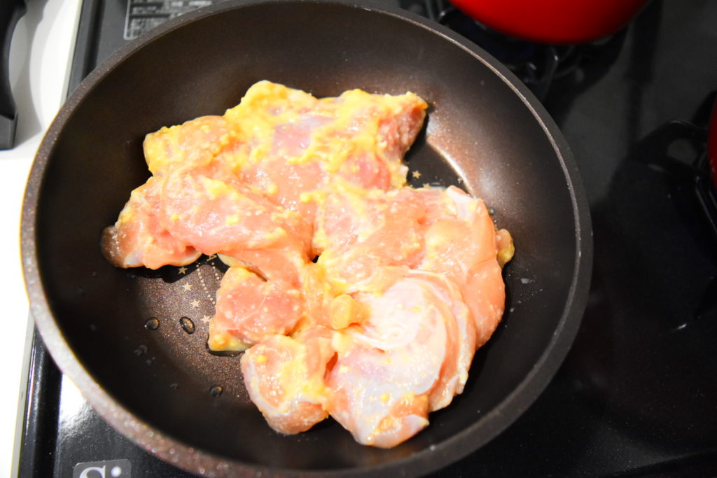 フライパンに皮目を下にした鶏もも肉2つ