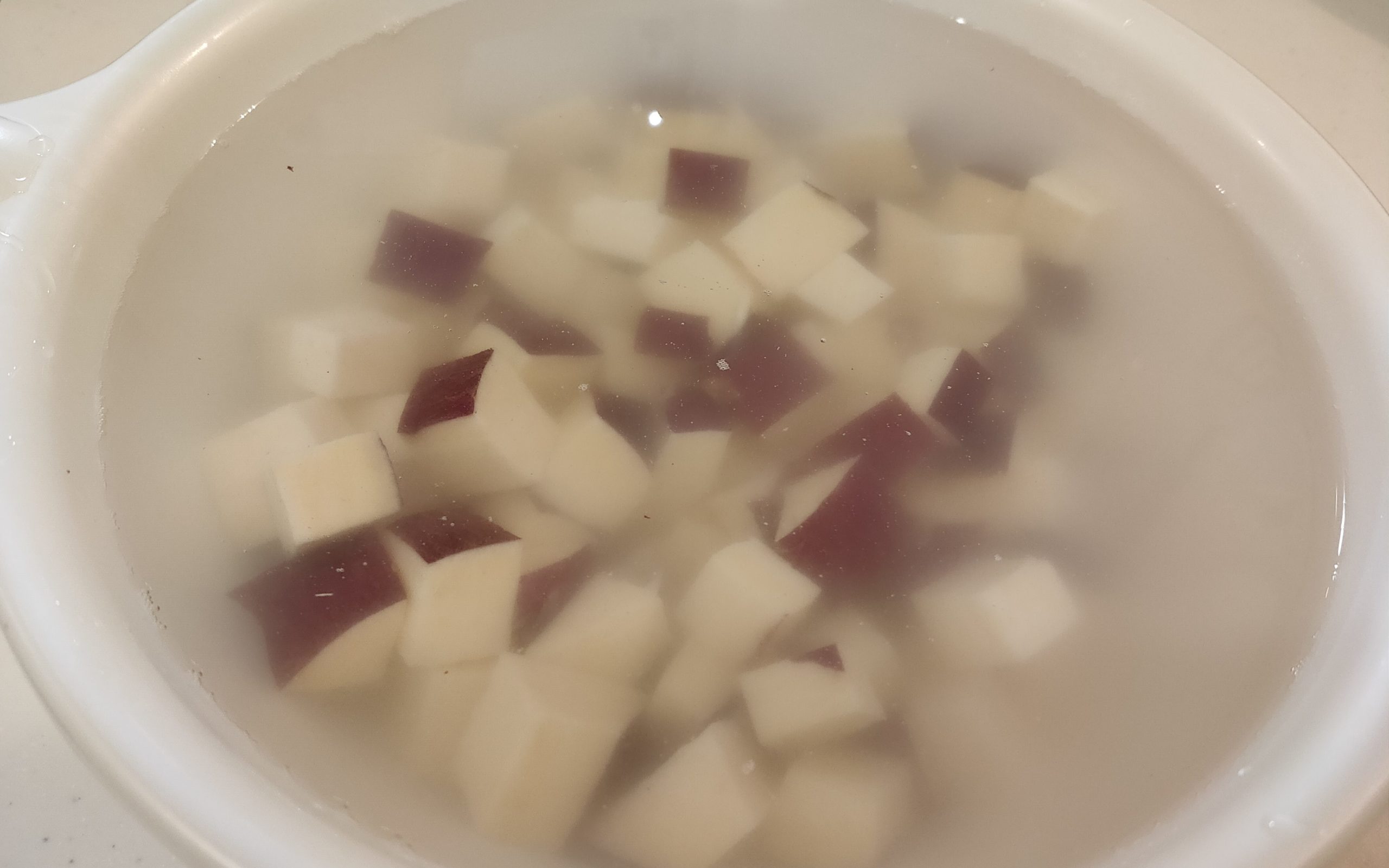 水を張ったボウルに切ったさつまいもを入れる