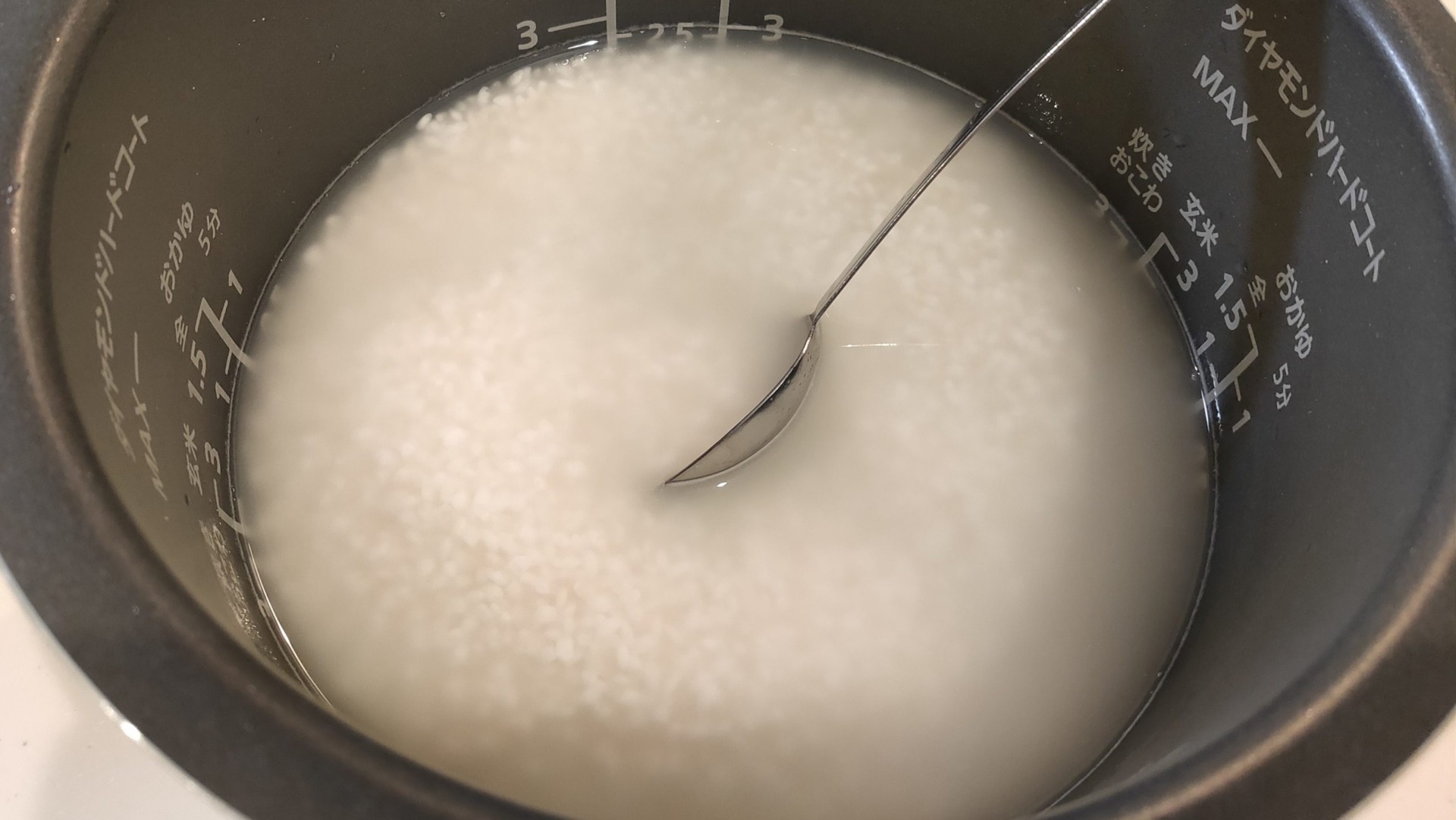 ご飯の入った炊飯窯に調味料を入れ混ぜる